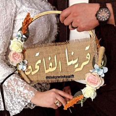 a man and woman dressed in traditional arabic garb holding a basket with flowers on it