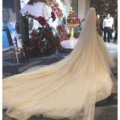 a woman in a wedding dress is walking down the street with her back to the camera