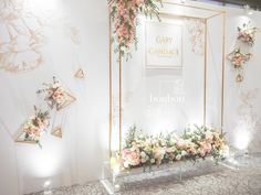 a white and gold wedding backdrop with flowers