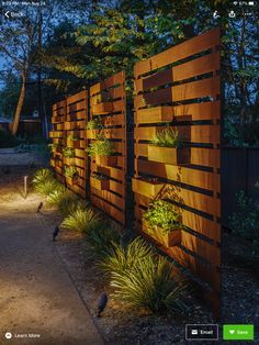 a wooden fence with plants growing on it at night in the park or garden area