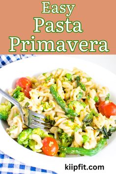 pasta with broccoli and tomatoes in a white bowl on a blue checkered table cloth