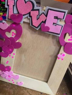 a photo frame decorated with pink and purple paper cut out letters that spell i love