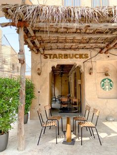 there is a starbucks coffee shop with chairs outside