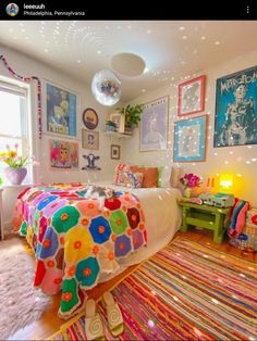 a bedroom decorated in bright colors with pictures on the wall and rugs around the bed