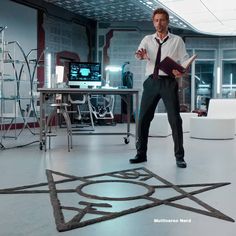 a man standing in an office holding a binder and looking at something on the floor