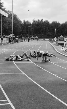 some people are laying on the ground in a race track