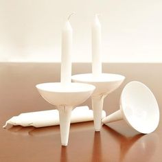 three white candles sitting on top of a wooden table