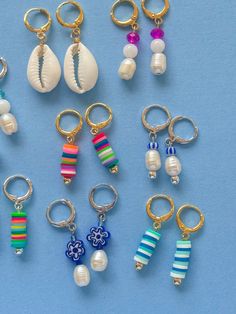 several different types of key chains with seashells and beads hanging from them on a blue surface