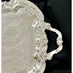 an ornate silver plate on a black background