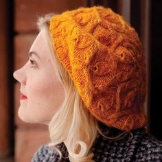 a woman with blonde hair wearing a yellow knitted hat and looking off into the distance