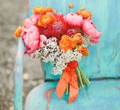 a bouquet of flowers sitting on top of a blue chair with the words good morning