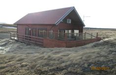 a small red house sitting on top of a dry grass field