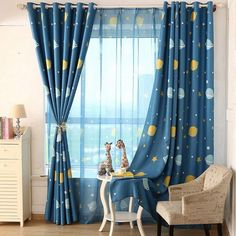 a child's room with blue curtains and giraffes