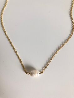 In the Philippines pearls are a national gem! They represent the richness of beauty the stunning sea life brings to the islands. A simple single pearl sits in the center of this gold filled chain. 15" long. Gold Pearl Pendant Necklace In 14k Gold Filled, Elegant Gold Shell Necklace With Pearl Charm, Everyday 14k Gold Filled Necklaces With Pearl Charm, Gold Single Strand Baroque Pearl Jewelry, Gold Single Strand Pearl Necklace As Gift, Pearl Jewelry With Delicate Chain And Round Beads, Minimalist Pearl Pendant Jewelry With Round Beads, Gold Single Strand Pearl Necklace For Gift, Gold Charm Necklaces With Pearl Pendant