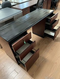 an office desk with several drawers on the bottom and one open drawer in front of it