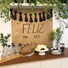 a table topped with cake and desserts next to a sign that says feliz dia dos pais