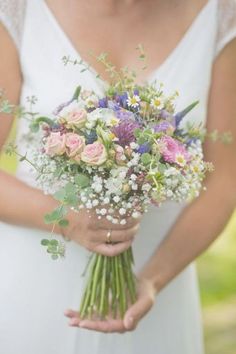 a woman holding a bouquet of flowers in her hands