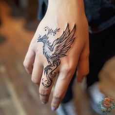 a woman's hand with a tattoo on it and a bird in the middle