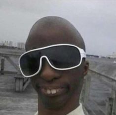 a man wearing sunglasses on top of a pier