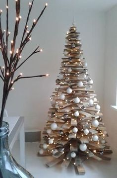 a small wooden christmas tree next to a bottle