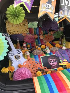 the back of a car decorated with mexican decorations and paper flowers, including an acoustic guitar