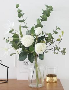 a vase filled with white flowers on top of a wooden table