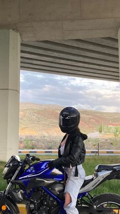 a woman sitting on top of a blue motorcycle