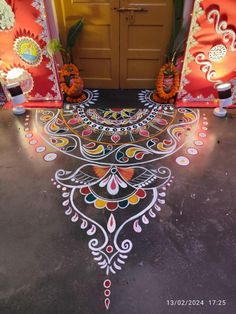 an intricately painted floor in front of a yellow door