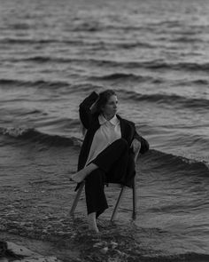 a woman sitting on a chair in the water