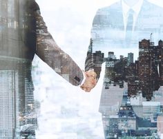 two business people shaking hands in front of cityscape