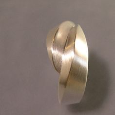 "This is a beautiful, softly curving ring, that for me speaks water and waves. A very sculptural piece that is made by first carving in wax, and then casting in the lost wax process. The width across the top of this ring is about 3/8\" and tappers down in the back to just over 1/8\". It is a very comfortable ring to wear. The piece shown is brush finish, but it can also be done in high polish. This ring is a size 7, but I can make any size needed...just let me know what you need in \"note to sel Lost Wax Casting Rings, Wax Carved Ring, Wax Ideas, Lost Wax Casting Jewelry, Yin Yang Ring, Lost Wax Jewelry, Wax Carving Jewelry, Modern Rings, Water Jewelry