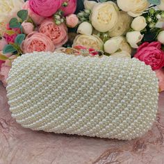 This luxurious encrusted pearl bridal clutch never fails to turn heads with its understated elegance and classic design. Adorned with varying sized ivory pearls and enhanced with a large creamy pearl clasp, this bridal clutch is the very picture of refinement. This elegant bridal clutch features rose gold trim, attachable chain and large enough for your phone. Complete your list of must-have wedding accessories with the ultimate bridal accessory to finish off your look and storing your wedding d Pearl Embroidered Party Clutch, Pearl Clutch With Pearl Embroidery For Evening, Pearl White Clutch For Parties, Gold Clutch With Pearl Embroidery, Gold Pearl Clutch With Pearl Embroidery, Formal Gold Clutch With Pearl Material, Party Clutch In Pearl White With Pearl Embroidery, Elegant Pearl Clutch With Pearl Handle, Elegant Pearl Clutch For Events