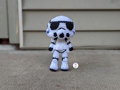 a crocheted star wars character with sunglasses and a button in front of a garage door