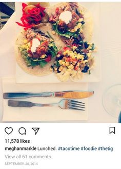 a white plate topped with two tacos covered in toppings next to a fork and knife