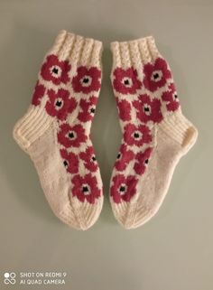 two white socks with red flowers on them