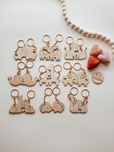 several wooden keychains with different designs and animals on them next to a bead necklace