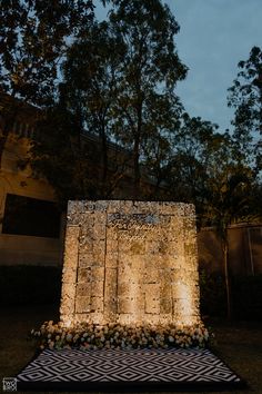 an outdoor area with lights and flowers on the ground