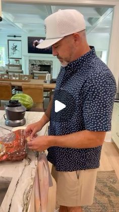 a man standing in front of a kitchen counter preparing food on top of a cutting board