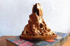 a wooden sculpture sitting on top of a book