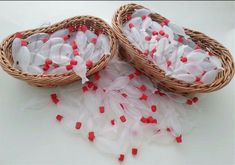 two baskets filled with white and red confetti on top of a blue background