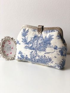 "** Unique Design Hand stitched clutch with bronze color vintage metal frame ** ~~ Frame purse made with beautiful pastoral print from Toile de Jouy.   * The term, Toile de Jouy, originated in France in the late 18th century, in french it means \"cloth from Jouy-en-Josas\", a town in the south-west suburbs of Paris. * The theme in toile of jouy is mostly scenery, with very detailed print.   ~~ Purse front and back pattern is different ~~ ~~ Frame purse pattern is designed by myself, I have use a Vintage Clutch Coin Purse, Vintage Handmade Pouch, Vintage Handmade Pouch For Everyday, Vintage Coin Purse With Zipper For Daily Use, Vintage Coin Purse For Daily Use, Vintage Rectangular Clutch With Zipper, Vintage Clutch Pouch As Gift, Vintage Handmade Clutch For Everyday Use, Vintage Clutch Pouch For Gift