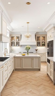 a large kitchen with wooden floors and white cabinets