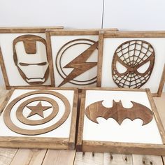 four wooden cut outs with various superhero logos