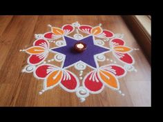 a candle is lit in the middle of a colorfully decorated rangolite design