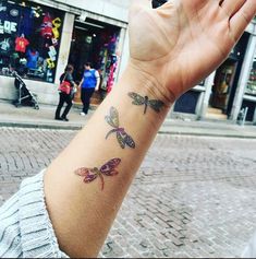 a person with a tattoo on their arm is holding up her hand in the air