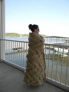 a woman standing on a balcony looking out at the water