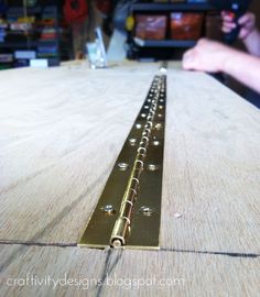 a close up of a wooden table with metal brackets on the top and bottom edge