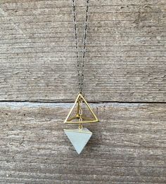 Geometric Necklace, Delicate, Art Deco, Architectural, Urban, Modern, MinimalistMake a simple and unique statement with a modern geometric necklace.  Smooth concrete tetrahedron shape is paired with a gold plated, geometric shape, creating a symbiotic balance. Brass chain is paired with a gold plated chain creating an ombre effect.Length of Brass Chain: 24" Necklace will be placed in a cloth bag- ready for gifting! Minimalist Triangle Brass Jewelry, Minimalist White Triangle Jewelry, Minimalist Adjustable Geometric Jewelry, Minimalist Geometric Necklaces For Everyday, Concrete Necklace, Smooth Concrete, Geometric Pendant Necklace, Concrete Jewelry, Urban Modern