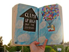 someone is holding up an open book with balloons in the shape of a house and a sign that reads climb up high drop the journal