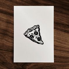 a piece of pizza sitting on top of a white paper next to a wooden table